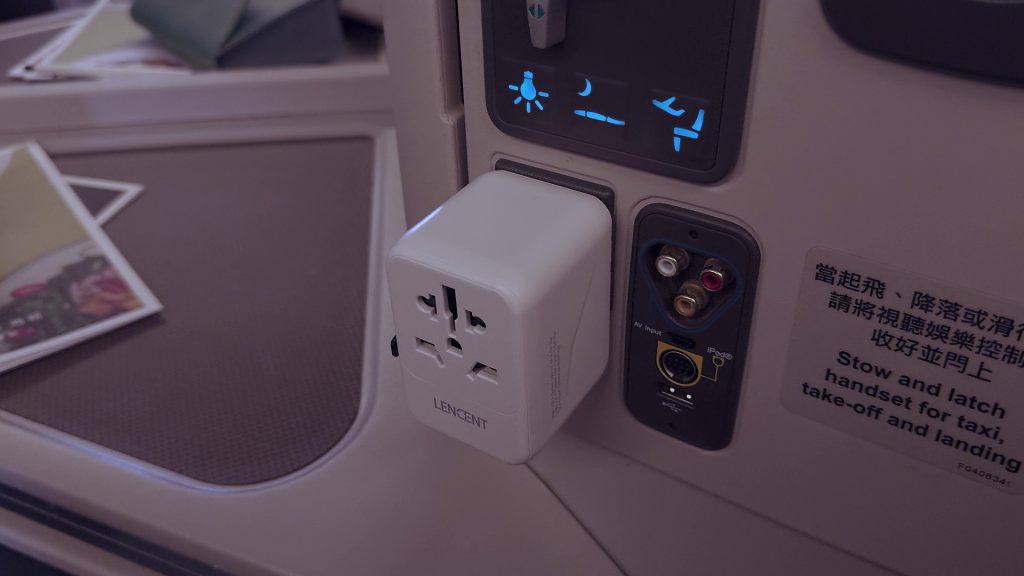 Lencent travel power adapter powering multiple devices at Cathay business class seat